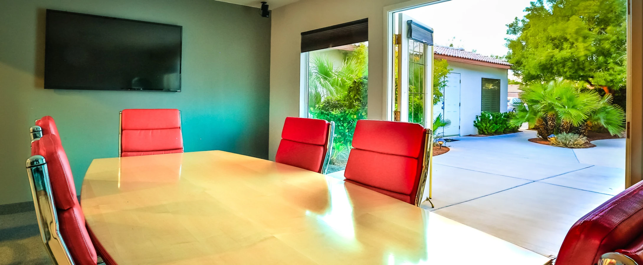 Our conference room table with open doors to the pool at our Las Vegas office location