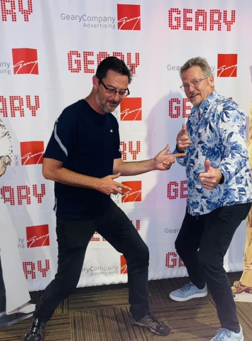 Jim and Dan posing like Elvis at an event.